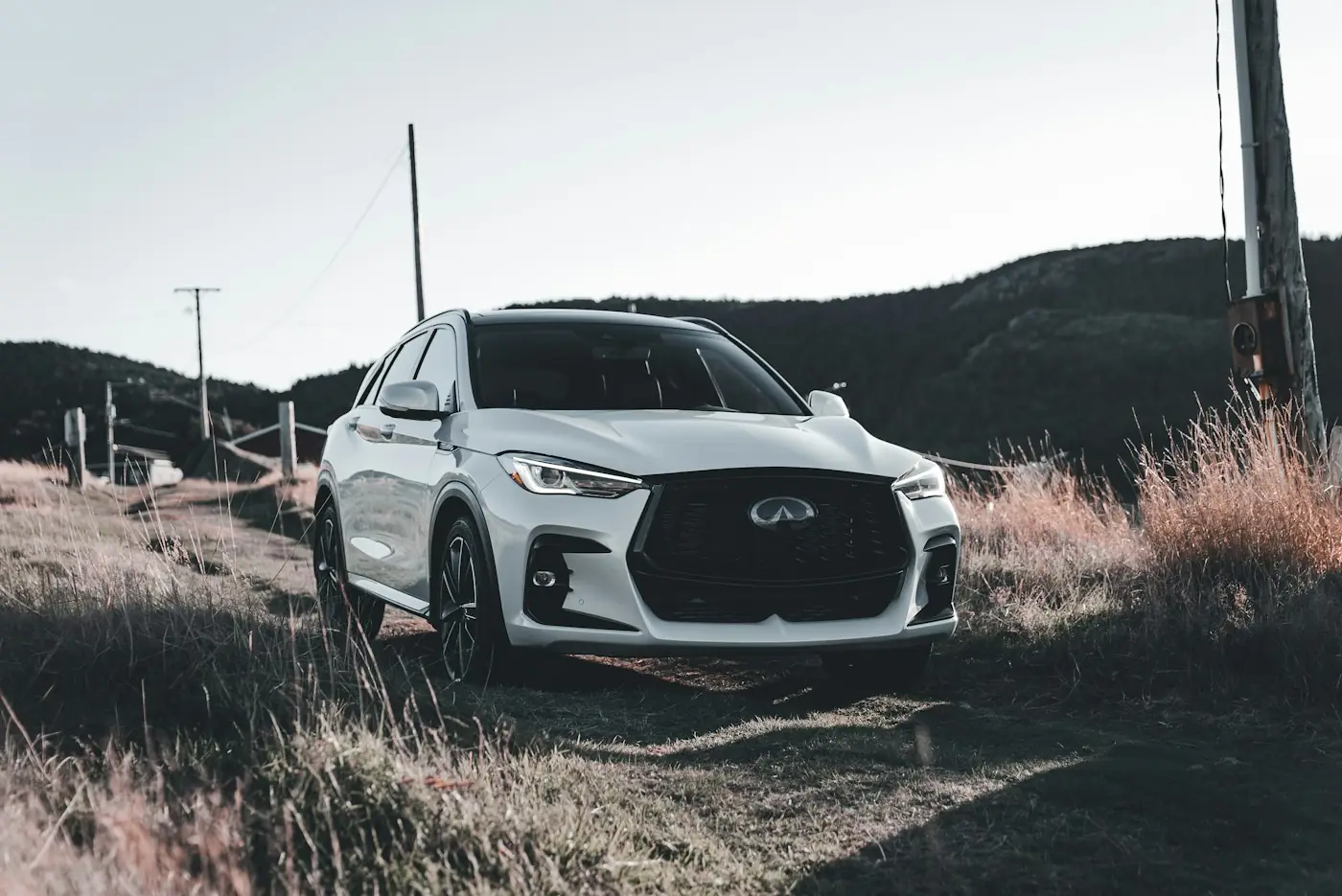 White midsize SUV parked in a grassy field