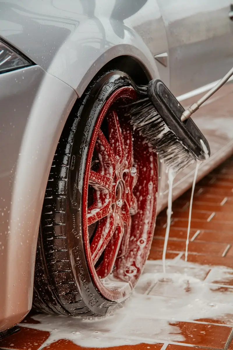 Brushing a red wheel covered in suds